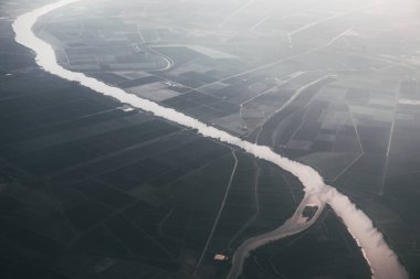Endülüs 'te akan Guadalquivir nehrinin hava manzarası. Huzurlu nehir, doğanın güzellikleriyle çevrili canlı bir tarladan yavaşça akar.