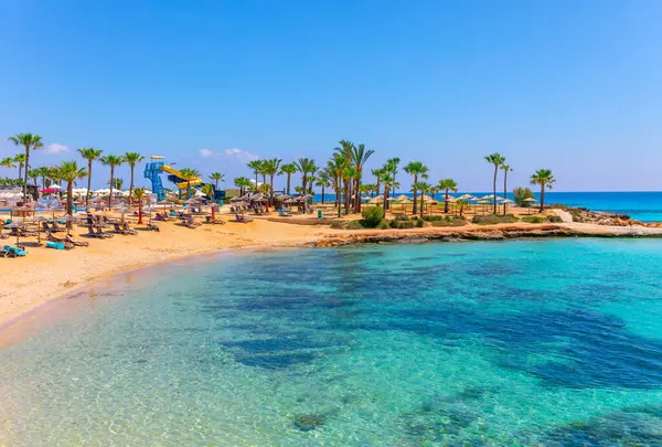 Ayia Napa, Kıbrıs Rum Kesimi 'nin altın kumlu plajları ve turkuaz suları, palmiye ağaçları ve güneş pansiyonları tropik bir cennet yaratıyor. Rahatlamak için mükemmel, su kaydırakları ve manzaralı kıyı manzarası gibi hareketli cazibeleri var.