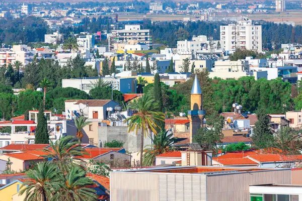 Lefkoşe 'nin önde gelen unsurlarından oluşan şehir manzarası arasında konut binaları, minareli bir cami ve kentin kültürel miras ve kentsel kalkınma karışımının altını çizen yemyeşil bir cami yer alıyor.