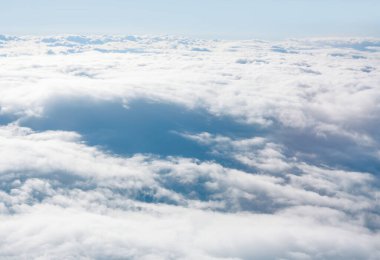 Bulutların üstünden görebildiğin kadar uzağa uzan. Gökyüzü kabarık beyaz bulutlarla dolu, görülecek bir manzara.
