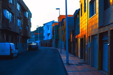 Günbatımında Gran Canaria 'da canlı şehir caddesi, modern binalara yansıyan sıcak altın ışıkla. Huzurlu ama dinamik bir atmosfer, eşsiz bir adayı vurguluyor mimari ve sakin bir akşam havası.