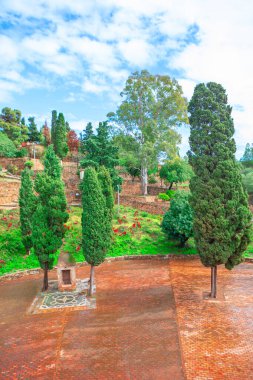 Tuğla bir yol üzerinde yükselen yemyeşil ağaçların olduğu sakin bir açık hava sahnesi. Küçük kubbe şekilli yapı cazibe ve denge katar, resim gibi ve huzurlu atmosferi arttırır.