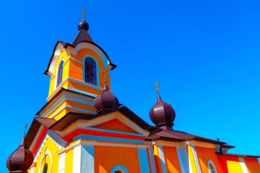 Moldova 'dan Tipova Kilisesi. Açık mavi gökyüzüne karşı canlı turuncu ve sarı kilise mimarisi
