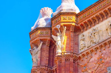 Barcelona 'daki Arco del Triunfo anıtının heykelleri. Karmaşık tarihi mimari, detaylı tuğlalar, heykeller ve fevkalade işçiliği yansıtan yardım heykelleri sergileniyor.
