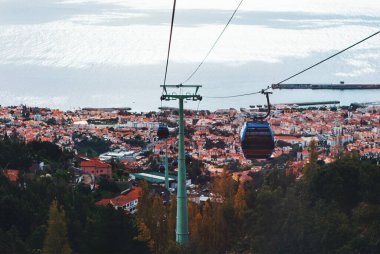 Funchal, Madeira 'ya doğru inen teleferik şehir terasotta çatıları, liman ve parıldayan Atlantik Okyanusu' nun panoramik manzarasına sahip. Şehir cazibesi ve doğal güzelliğin doğal bir karışımı.