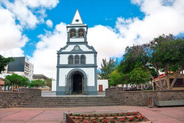 Fuerteventura, Kanarya Adaları 'ndaki Puerto de Rosario' daki tespih kilisesinin leydisi. Mavi gökyüzüne karşı kurulmuş büyüleyici beyaz kilise. Kilise çan kulesinin tepesinde üçgen çatı ve görünür çanlar var.