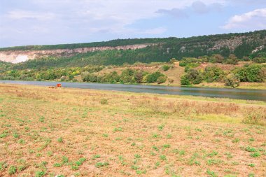 Nehir kenarındaki sakin kırsal bölge. Nehir vadisinin sakin manzarası, engebeli tepeler. Kuru tarlaları ve ormanlık tepeleri olan huzurlu nehir vadisi.