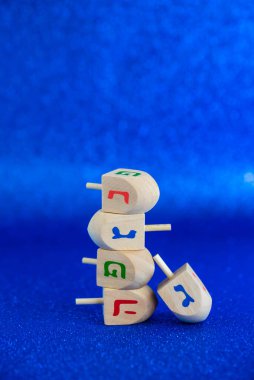 Jewish holiday Hanukkah concept. Wooden dreidel (spinning top) on blue background.