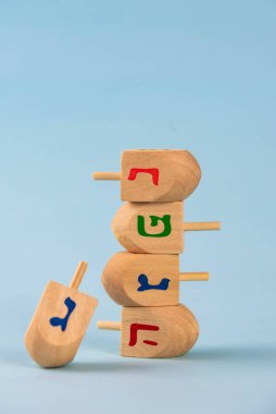 Jewish holiday Hanukkah concept. Wooden dreidel (spinning top) on blue background.