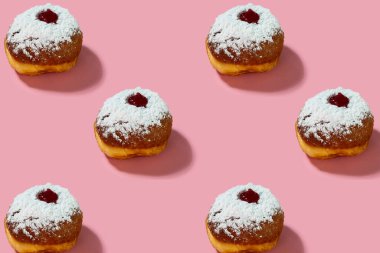 Jewish holiday Hanukkah concept. Pattern with donut sufganiyot on a pink background.