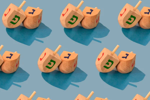 Jewish holiday Hanukkah concept. Wooden dreidel (spinning top) on blue background.