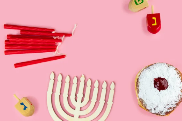 Jewish holiday Hanukkah concept. Menorah - traditional candelabrum or hanukkiah, donut sufganiyot and wooden dreidel - spinning top