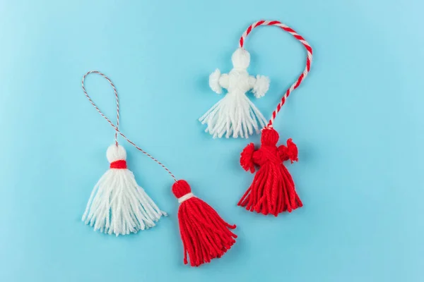 stock image Traditional Martisor - symbol of holiday 1 March, Martenitsa, Baba Marta, beginning of spring and seasons changing in Romania, Bulgaria, Moldova. Greeting and post card for holidays. Blue background.