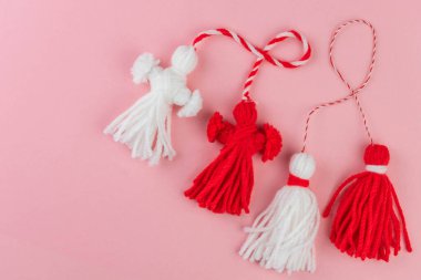 Traditional Martisor - symbol of holiday 1 March, Martenitsa, Baba Marta, beginning of spring and seasons changing in Romania, Bulgaria, Moldova. Greeting and post card for holidays. Pink background.