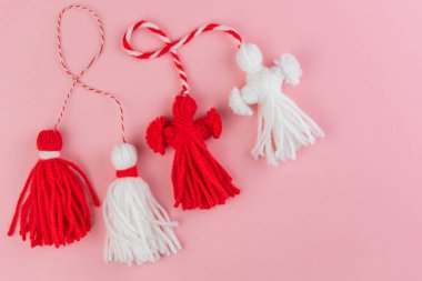 Traditional Martisor - symbol of holiday 1 March, Martenitsa, Baba Marta, beginning of spring and seasons changing in Romania, Bulgaria, Moldova. Greeting and post card for holidays. Pink background.