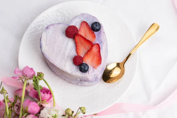 在床的背景下 一份清淡的早餐中 时尚的本托蛋糕在爱情的心形中形成 情人节 母亲节或生日的蛋糕 永恒的爱的信息 浪漫的贝托蛋糕 图库图片