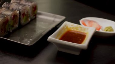 Japon yemeklerini yiyen çubuklarla ellerini yaklaştır. Geleneksel Asya dürümleri. Sebzeli ve ton balıklı Maki suşi.