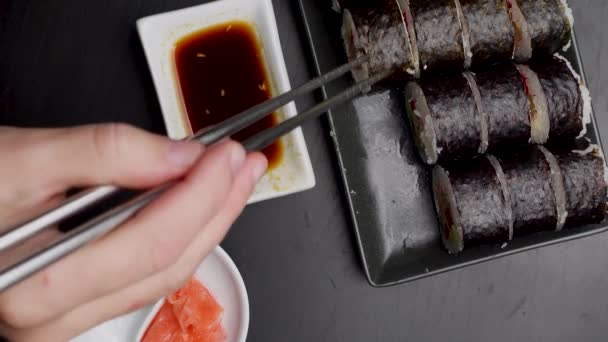 用筷子把吃日本菜的人的手拉近 传统的亚洲卷 马基寿司加蔬菜和金枪鱼 — 图库视频影像