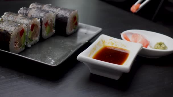 日本食を食べる箸で手を閉じる 伝統的なアジアのロール 野菜とマグロを使った焼き寿司 — ストック動画