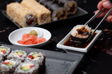 Japon yemeklerini yiyen çubuklarla ellerini yaklaştır. Geleneksel Asya dürümleri. Sebzeli ve ton balıklı Maki suşi.