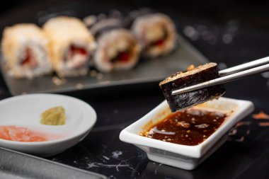 Japon yemeklerini yiyen çubuklarla ellerini yaklaştır. Geleneksel Asya dürümleri. Sebzeli ve ton balıklı Maki suşi.