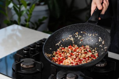 Şef 'in elleri fırında soğan, biber, şitake mantarı, lahana, tavada sarımsak pişirirken yakın plan..