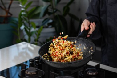 Şef 'in ellerini yakın pişirin ve fırında soğan, biber, şitake mantarı, lahana, tavada sarımsak pişirin. Uçan yiyecek havalanması.