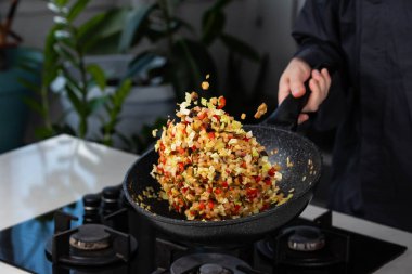 Şef 'in ellerini yakın pişirin ve fırında soğan, biber, şitake mantarı, lahana, tavada sarımsak pişirin. Uçan yiyecek havalanması.