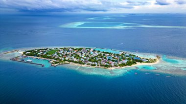 Drone Aerial Photo Of Mahibadhoo Island in the Central Maldives surrounded by the deep blue ocean waters of the Indian Ocean clipart