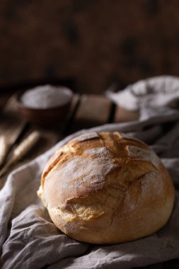 Tahta masada taze ekmek ve masa örtüsü. Fırın ahşap masa üstünde hayat ve ekmek
