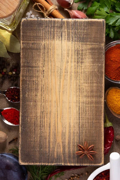 テーブルの背景に木のまな板とスパイスやハーブの様々な テーブルトップビューでの料理のコンセプトと食材 — ストック写真