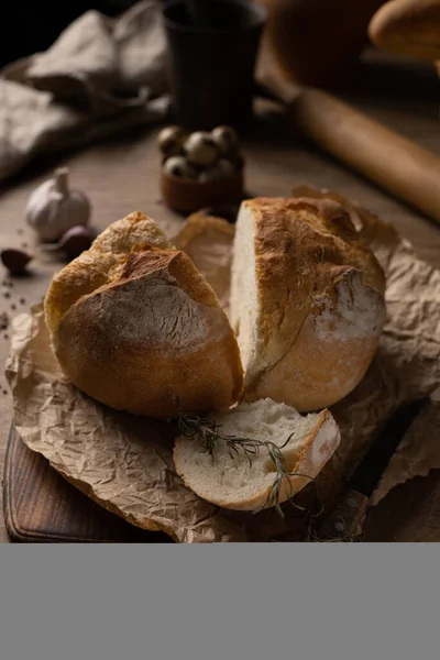 自制面包 木桌上有羊皮纸 面包在木制桌面上烘烤的概念 图库图片