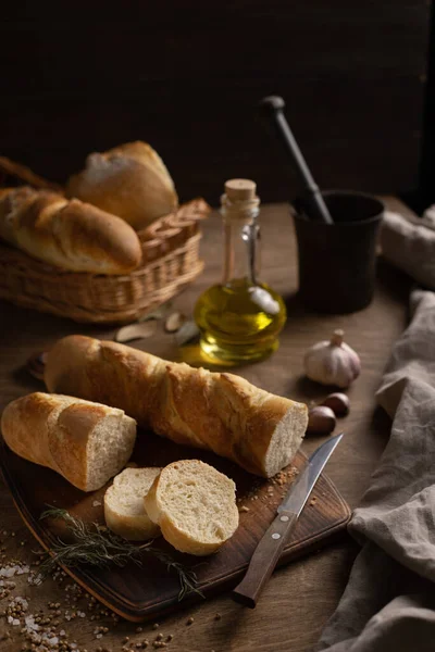 切法国面包 木桌上有切菜板 作为烘烤概念的木制桌面自制面包 图库照片