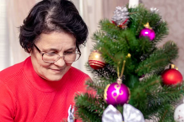 A woman decorates a Christmas and New Year tree. Preparation for Christmas and New Year