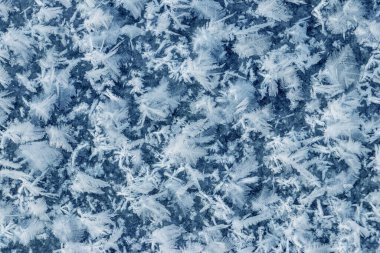 Big fluffy snowflakes on the surface of the ice. Winter and Christmas background