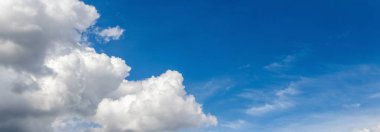 Mavi gökyüzünde güneşli beyaz bulutlar