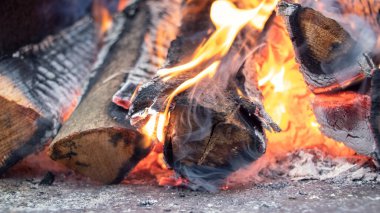 Şöminede odun ve kömürle birlikte ateş var. Yakacak odun yanıyor.