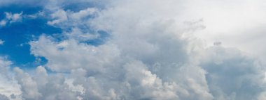 White whimsical clouds in the blue sky in sunny weather