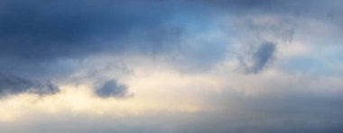 Dramatic sky with dark small clouds at sunset, panorama
