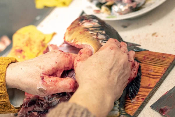 Woman Cuts Fish Large Knife Home Kitchen — Stockfoto