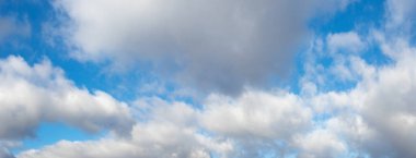 Güneşli havada beyaz kıvırcık bulutlu mavi gökyüzü