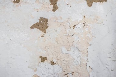 Beyaz boyalı bir duvarın dokusu ve soyulmuş boya izleri.