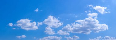 Güneşli havada mavi gökyüzünde beyaz kıvırcık bulutlar