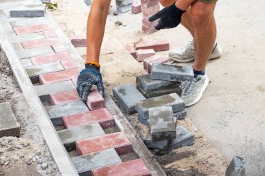 Bir işçi evin önündeki merdivenlere asfalt döşeyerek yatıyor.