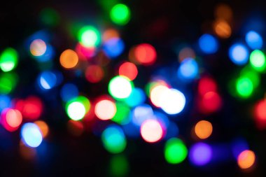 Noel ve yeni yıl arkaplanı Bokeh, siyah arkaplanda bulanık ışıklar