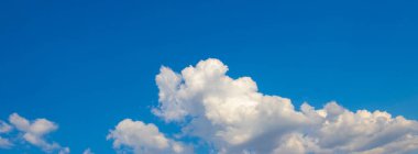 Güneşli havada mavi gökyüzünde beyaz kıvırcık bulutlar