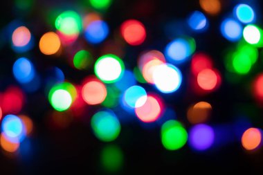 Noel ve yeni yıl arkaplanı Bokeh, siyah arkaplanda bulanık ışıklar