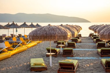 Sahilde şemsiyeli ve güneşli yataklı bir sahil.