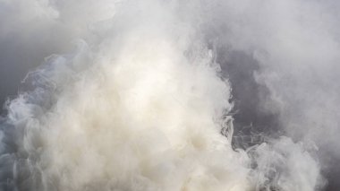 Güneş ışığında gri ve beyaz renkli dumanın dokusu