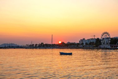 Akşamları deniz koyuyla birlikte gün batımında resimli manzara.